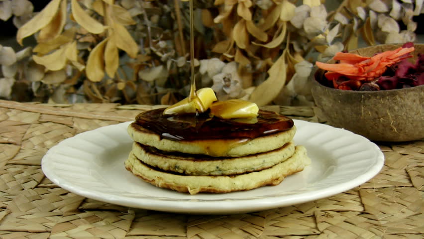 Pancakes With Dripping Maple Syrup (HD). Stack of pancakes with butter and Maple Syrup dripping slowly from above to melt the butter and cover the tower of flavor.