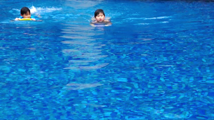 Boys swimming at a distance in the swimming pool.
