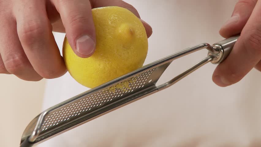Lemon zest being grated and added to dough ingredients
