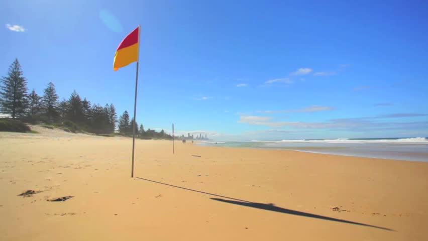 Sunny Australian beach with surf life saving flag on the Gold Coast, Queensland HD.