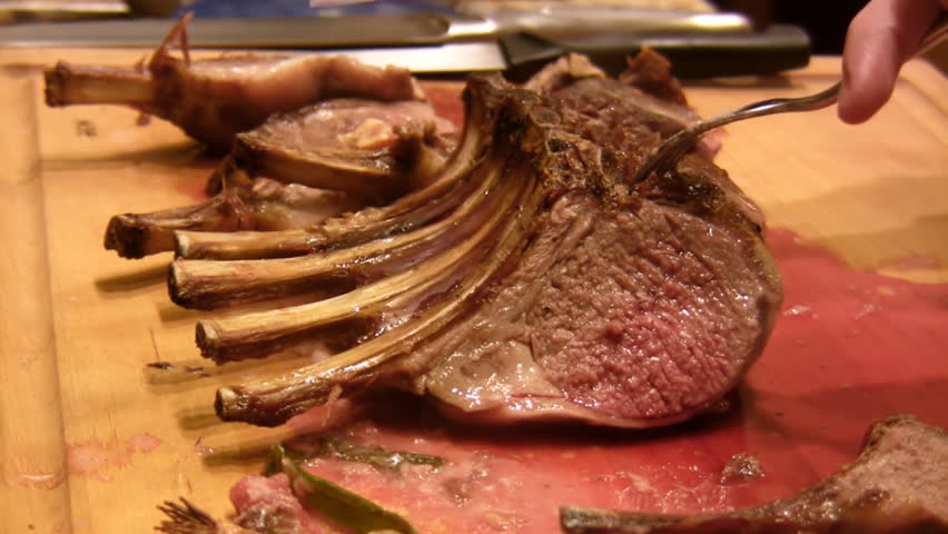 Rack of Lamb Chops (HD). Chef hand cutting a rare rack of lamb chops. 