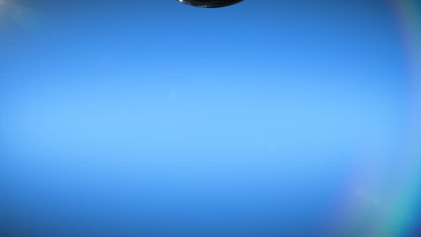 Water drop falling on blue background and splashing in slow motion, hd and alpha mask.