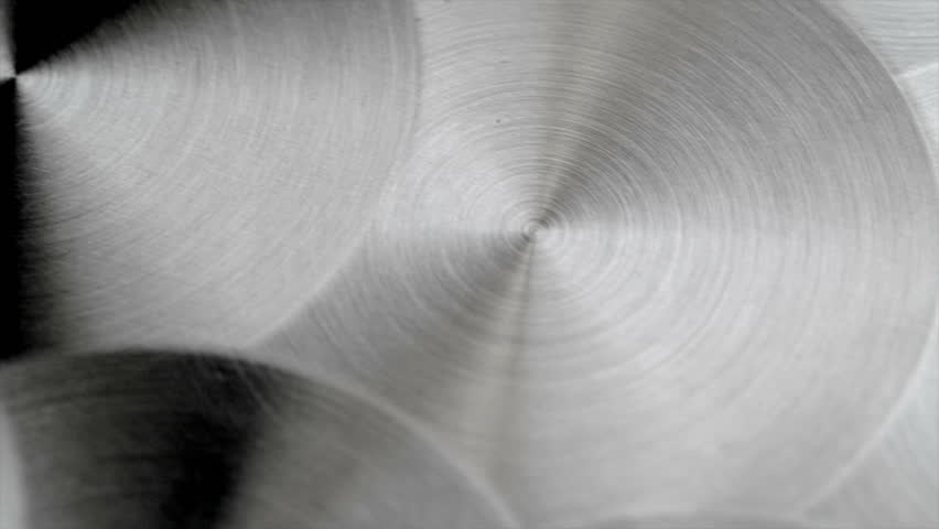Camera sliding above a sheet of circular brushed metal.