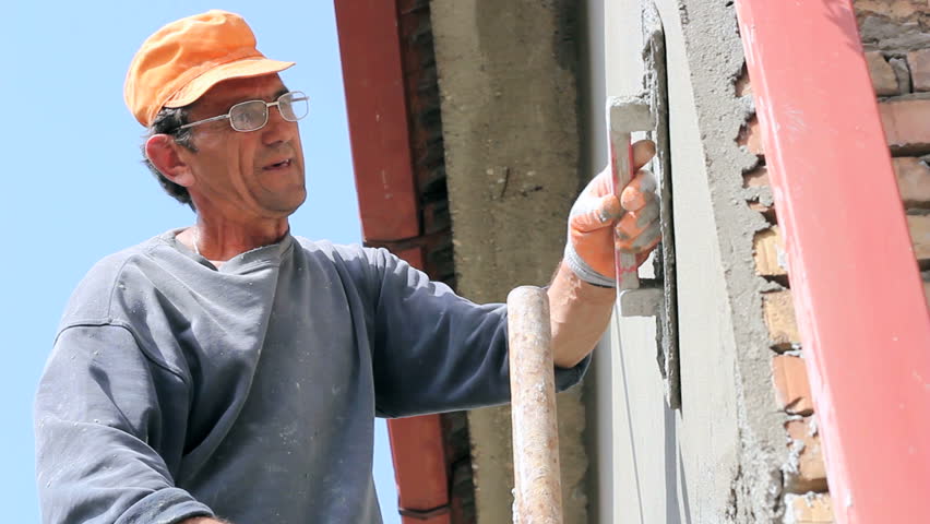 Mason worker plastering wall.
Mature contractor plasterer working outdoors. HD1080i.