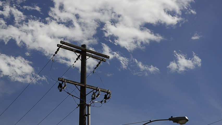 Power pole with blue sky and moving clouds in background