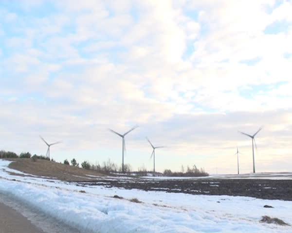 speed up view windmills rotating and clouds flow in sky. melting snow fields.