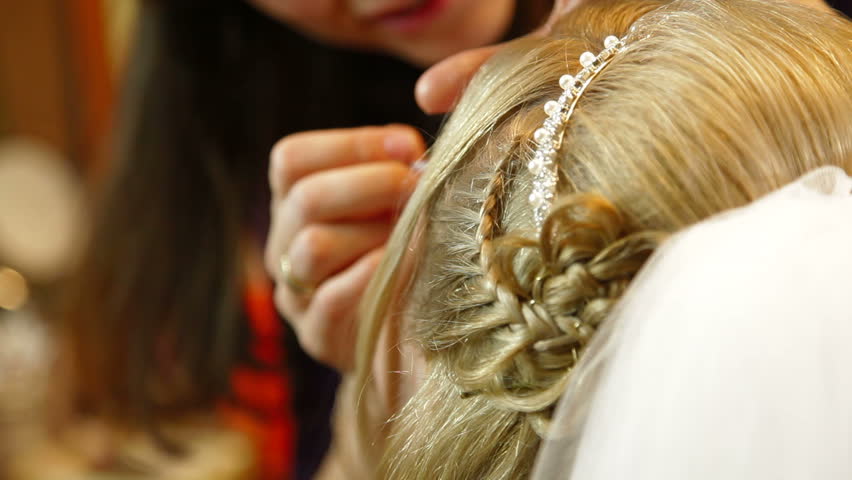 Closeup of a young bride applying cosmetics around her eye
