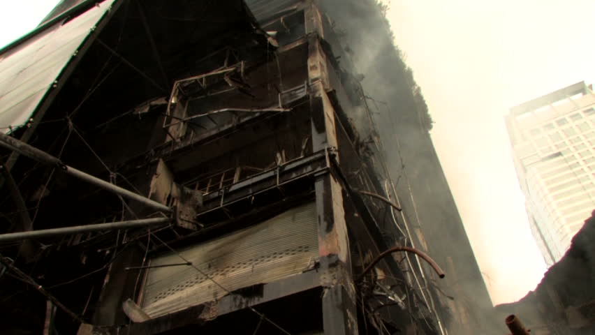 Building devastated by bomb attack fire arson smoking ruins 