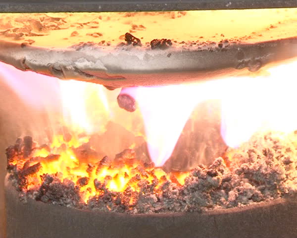 closeup of burning straw pellets in boiler. flames and fire details. ecologic fuel use for home heating.