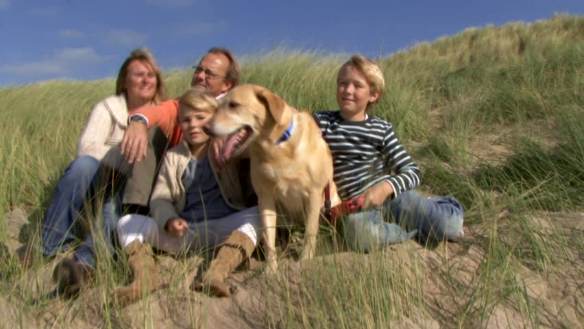 WIDE SHOT, Family portrait in dunes with dog