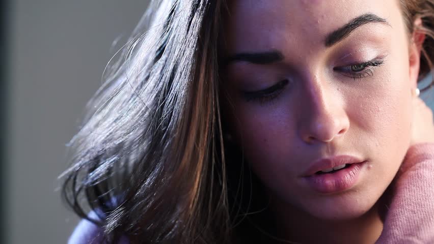 Close-up portrait of depressed teenager with head in hands crying and being sad