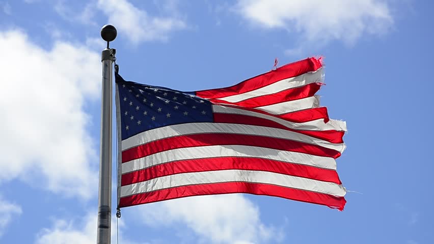 American Flag Blowing in the Wind with Blue Sky and Clouds in Background