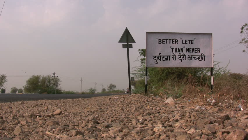 RAJKOT - 26 APRIL: A truck drives past a traffic sign on the way to Rajkot, India