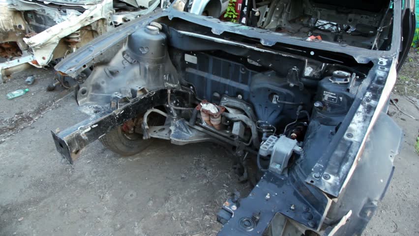 Several scrapped vehicles on junk yard, shown in motion