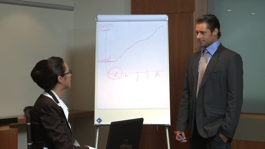 LONG SHOT OF A BUSINESSMAN GIVING A PRESENTATION