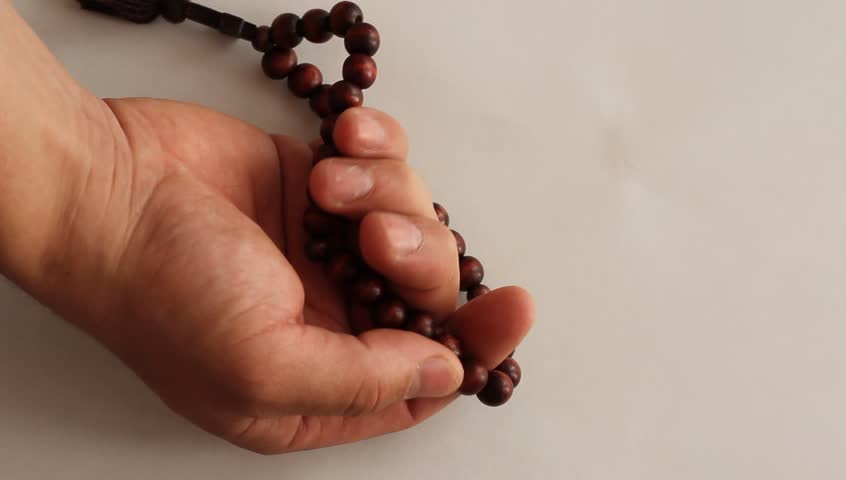 closeup of hands with rosary beads