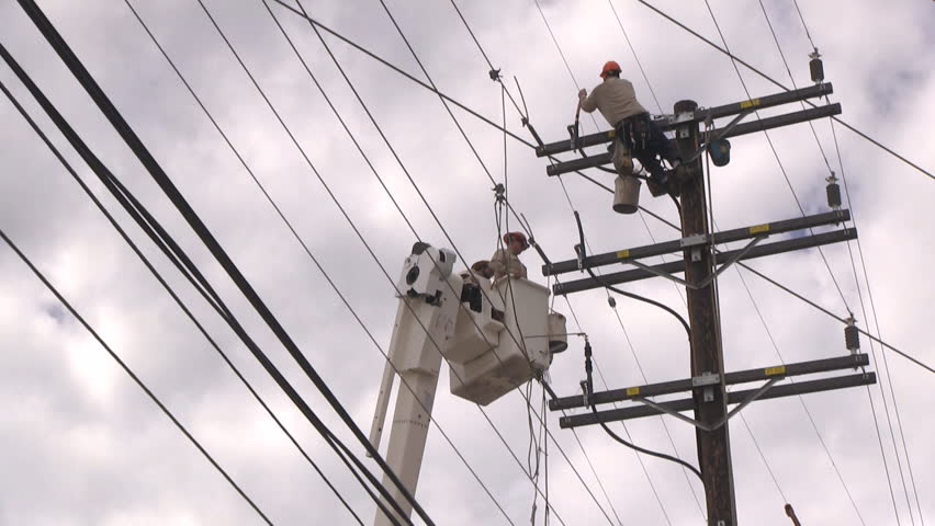 Three workers (two in a cherry picker) repair powerline.