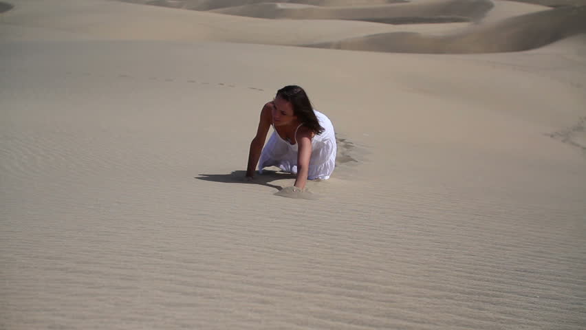 Young thirsty woman crawling in sand