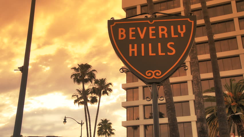 Beverly Hills, California - April 5, 2012: Traffic passes Beverly Hills Sign at Sunset, April 5, 2012 in Beverly Hills, California.
