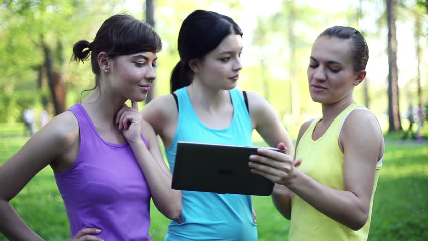Personal trainer with tablet computer explaining how to exercise
