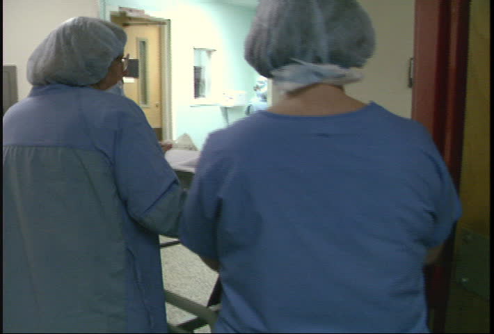 Nurses wheel patient to open heart surgery