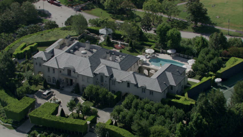 aerial view of an expansive 19th century mansion with manicured landscaping, pool, and surrounding property circa 2009