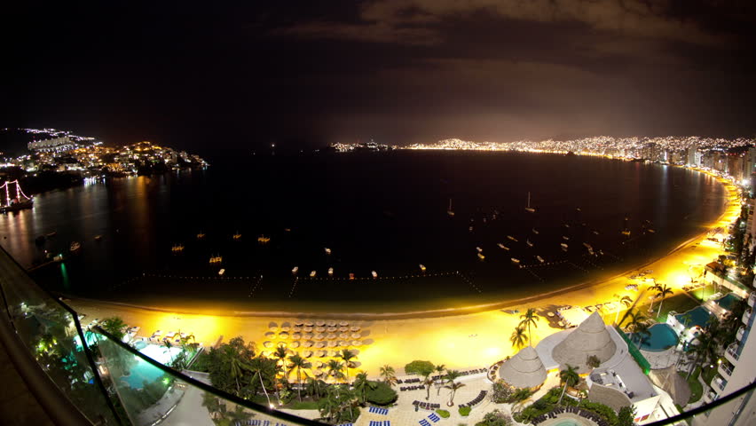 fisheye time-lapse at night of the huge bay of hotels stretching along the coast in acapulco, mexico
