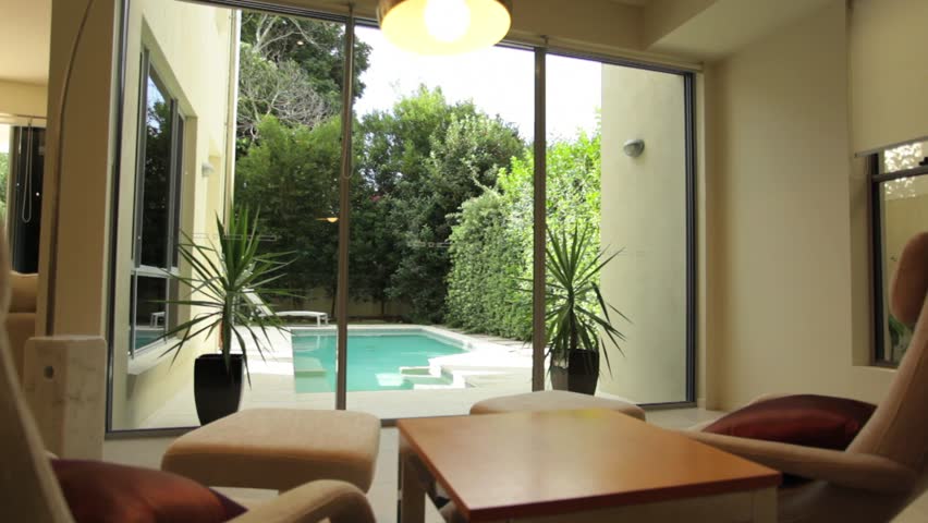 View of swimming pool from inside a luxury Australian home. Dolly shot.