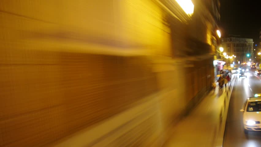 MADRID - MAR 10: (Timelapse View) Bus go near sidewalks on which people walk at night, on Mar 10, 2012 in Madrid, Spain