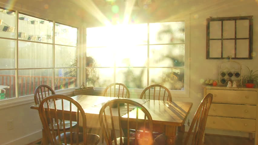 Bright sunset shines through window of dining room at house time lapse.