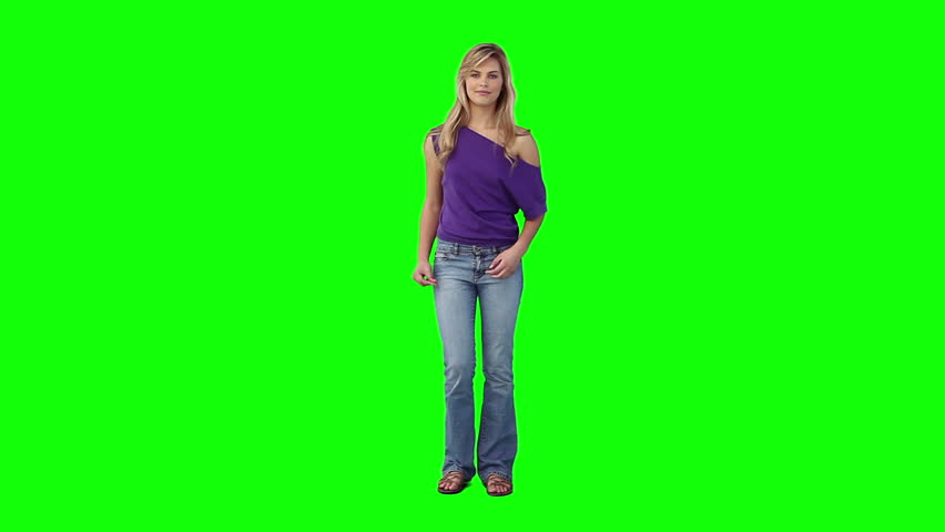 A blonde woman is dancing against a green background