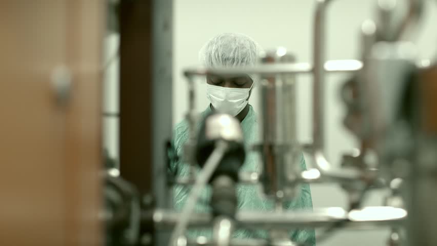 Lab technician working as researcher in biotechnology plant with machinery