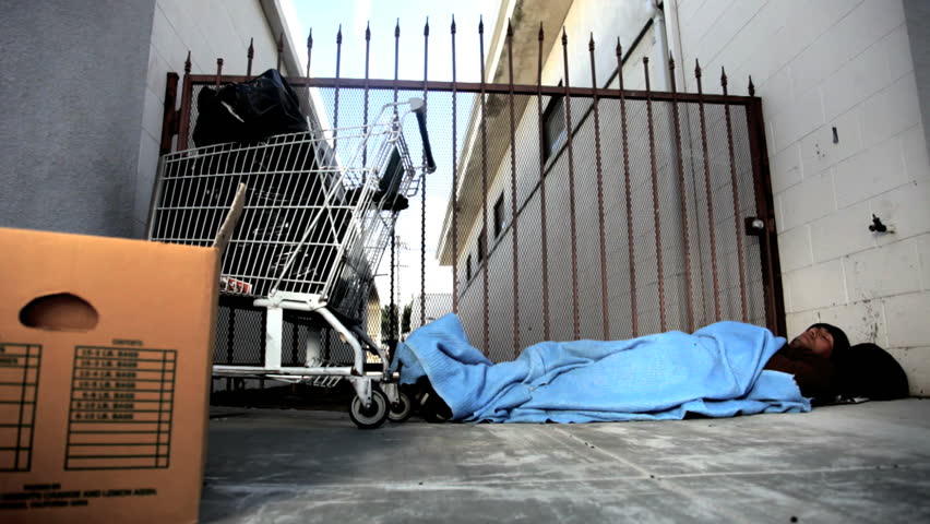 Homeless man trying to get some sleep in an alley