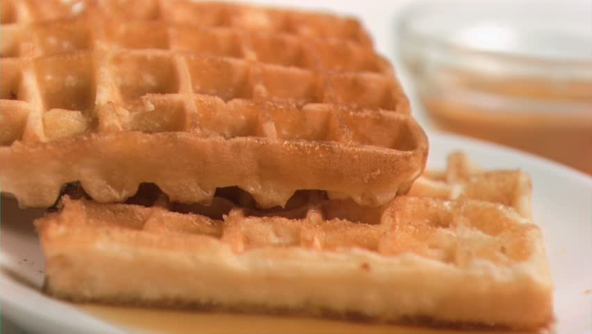 Maple syrup flowing in super slow motion on waffles