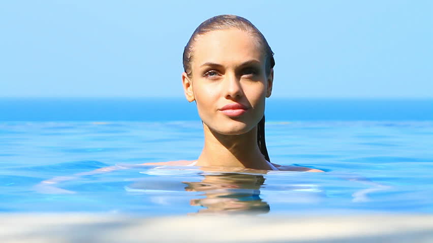 Sensual beauty relaxing in tropical swimming pool with a view

