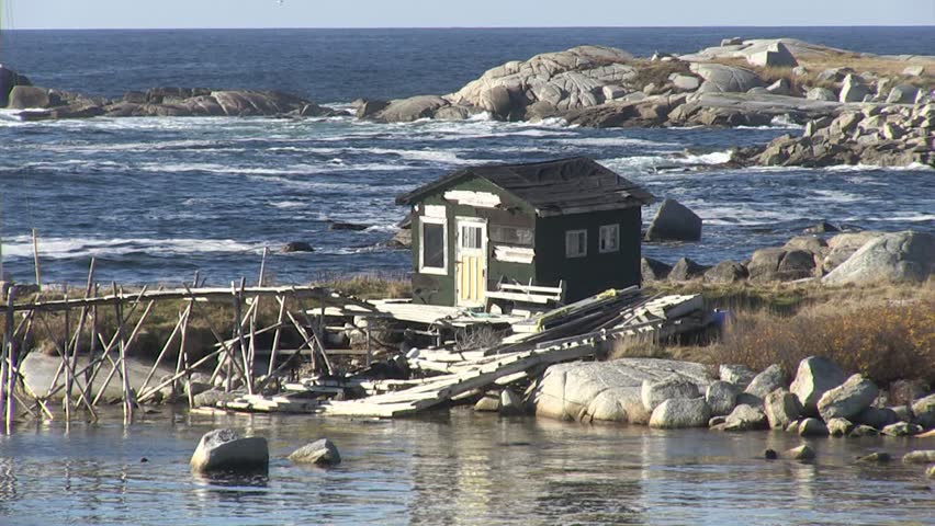 Fishing shack on the Atlantic Ocean.  The sunny day doesn't make the cold ocean look any more inviting.  Lots of waves breaking in the background, this dilapidated shack has seen better days.
