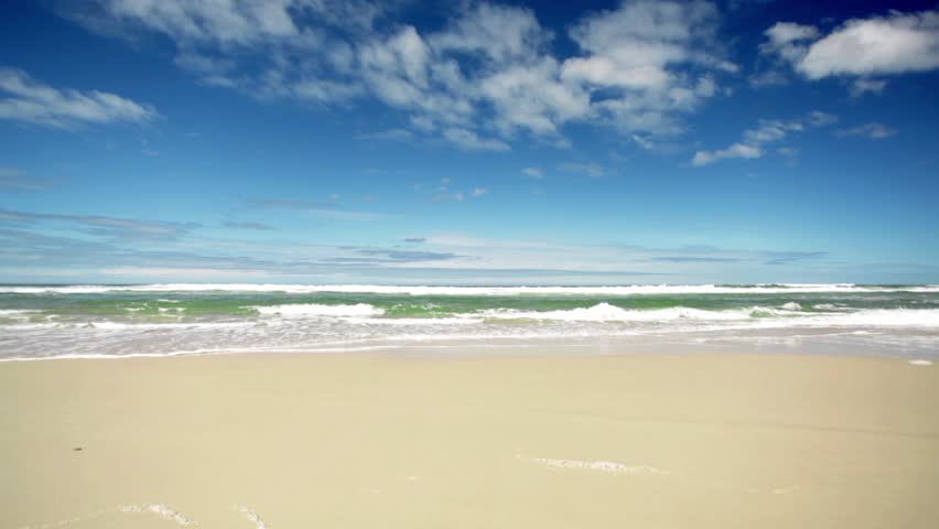 Pristine tropical beach washed by rolling waves, Queensland, Australia. HD