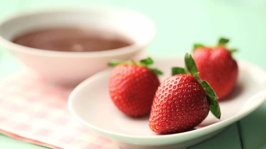 dipping strawberries on chocolate sauce
