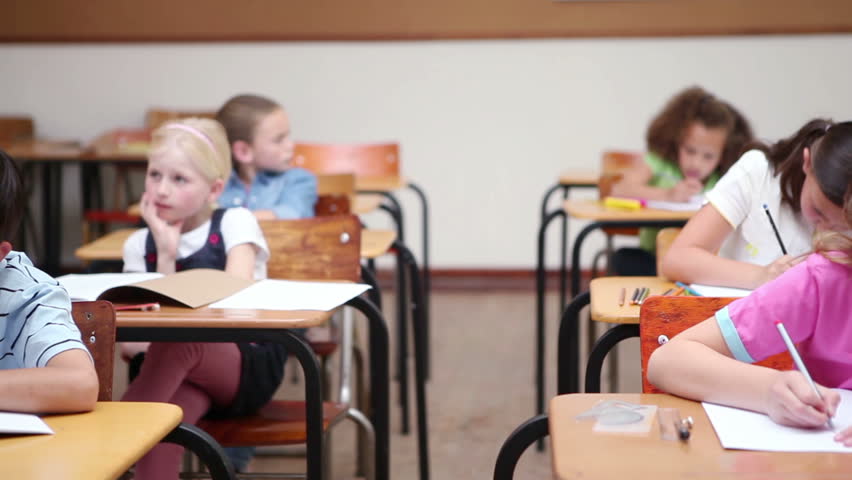 Pupils sitting at desks are working in a classroom