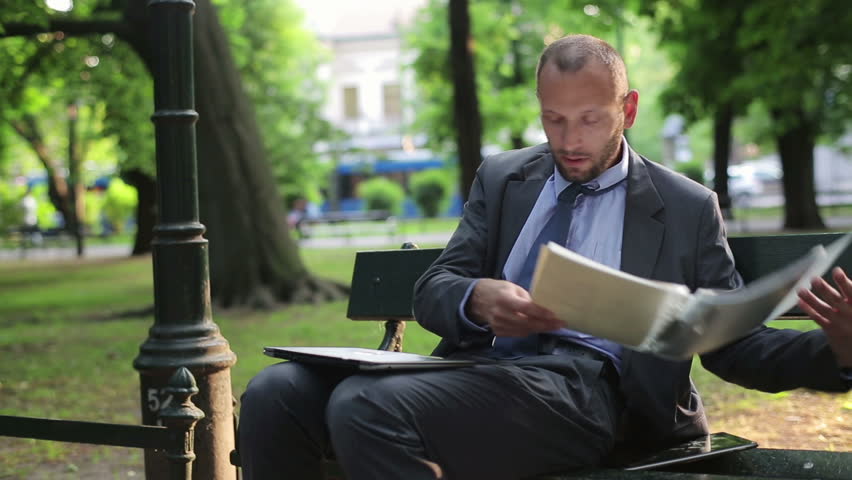 Busy multitasking businessman working in city park, time-lapse
