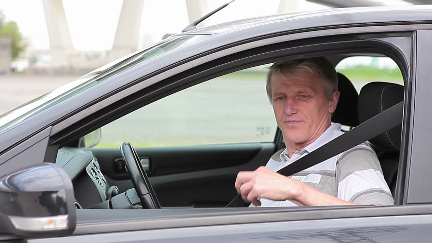 Mature Caucasian man showing ignition key, starting the car and get a move on