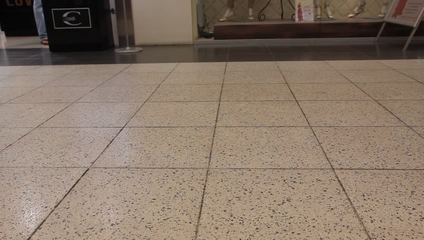 People at the shopping center walk past camera