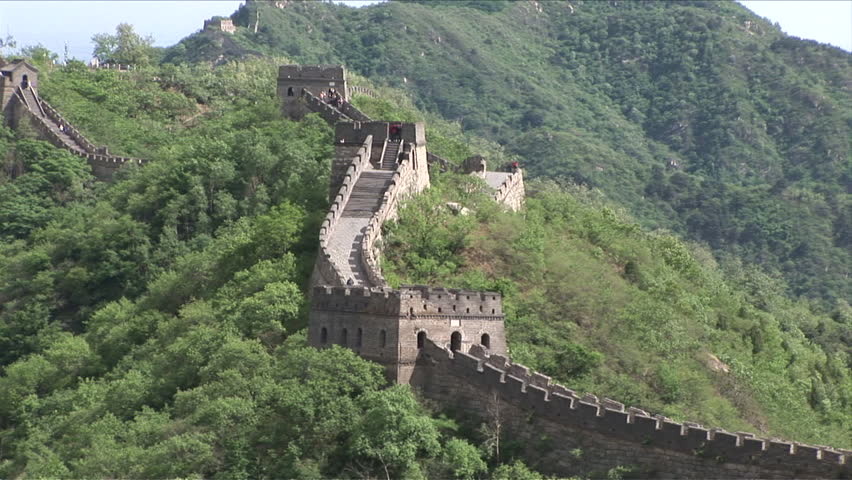 Wide shot of Great Wall of China with green mountains in the background in Beijing China