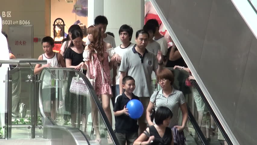 GUANGZHOU - AUGUST 9 2010: People are going down an escalator in a shopping mall in Guangzhou, China