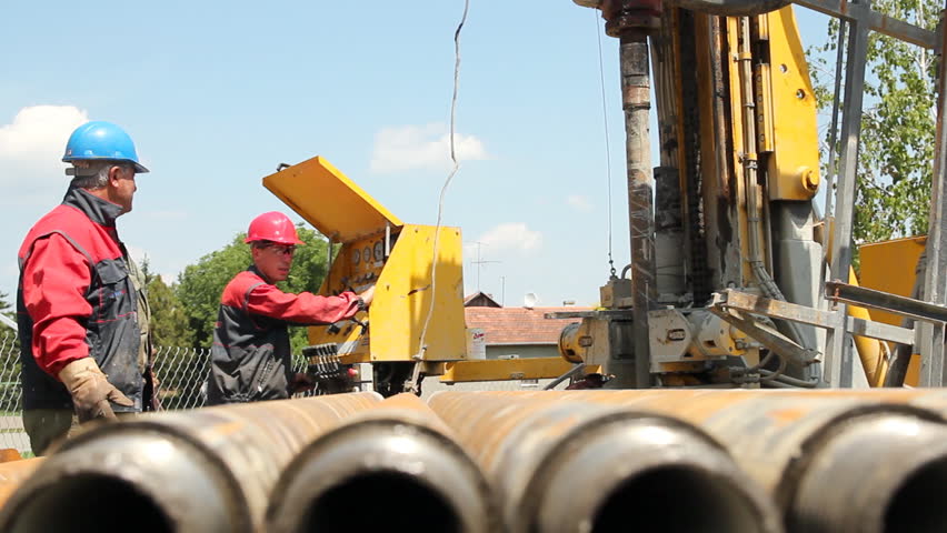 Oil drilling rig workers lifting drill pipe. HD1080p.