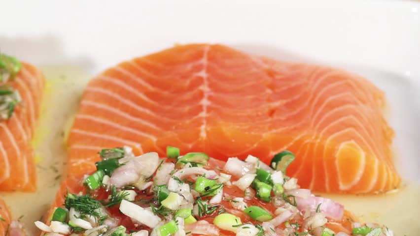 A marinade being spread onto salmon pieces