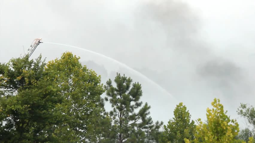 Lone Remote Control Ladder Mounted Water Cannon Sprays Water Downward At Outdoor Fire