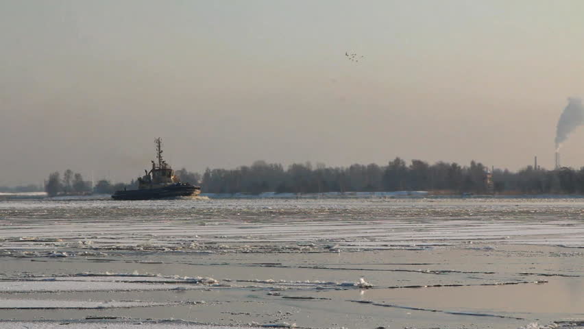 Tug boats moving through Riga port during Winter, in Riga, Latvia.