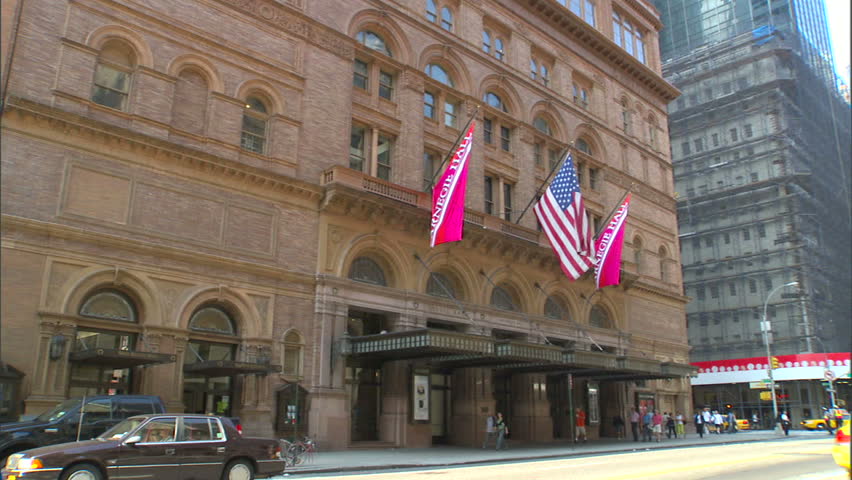 New York, NY - CIRCA 2006: A wide shot of Carnegie Hall in Manhattan during the day with traffic driving by