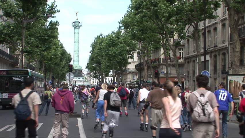 Paris, France - CIRCA June, 2006: A large group of rollerbladers skate in the middle of the street towards the Place de la Bastille on a beautiful summer day